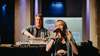 A singer and a DJ at the BRANDmania stage.